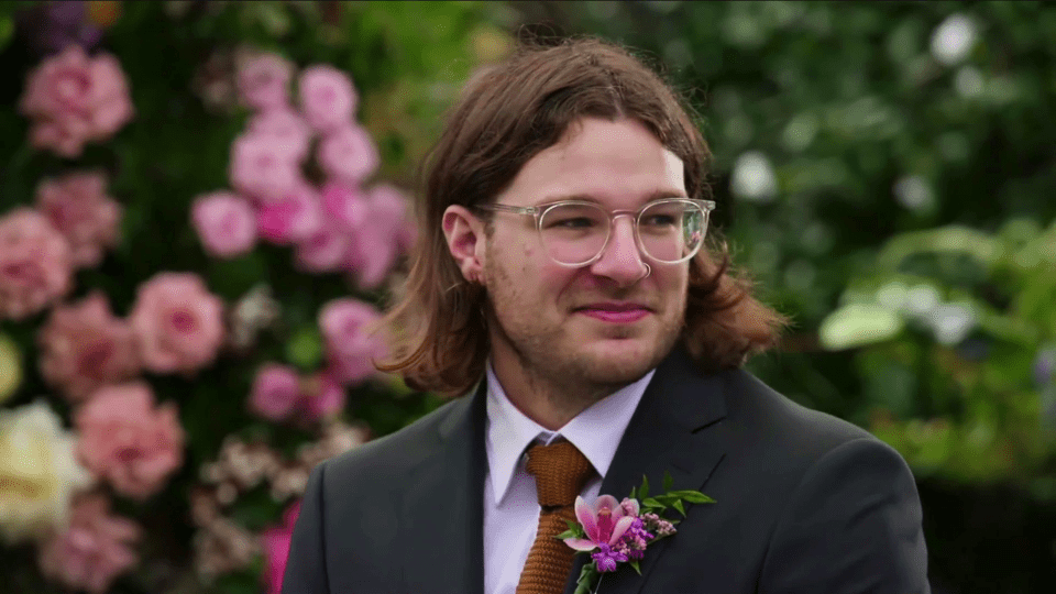 Groom at a wedding, looking slightly awkward.