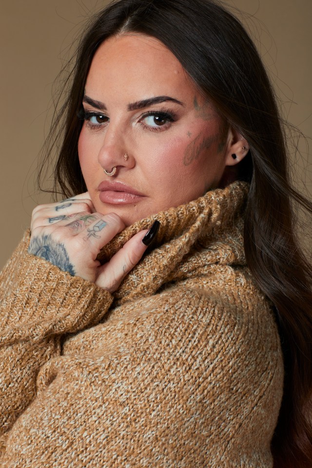Portrait of Jemma Lucy wearing a brown turtleneck sweater.