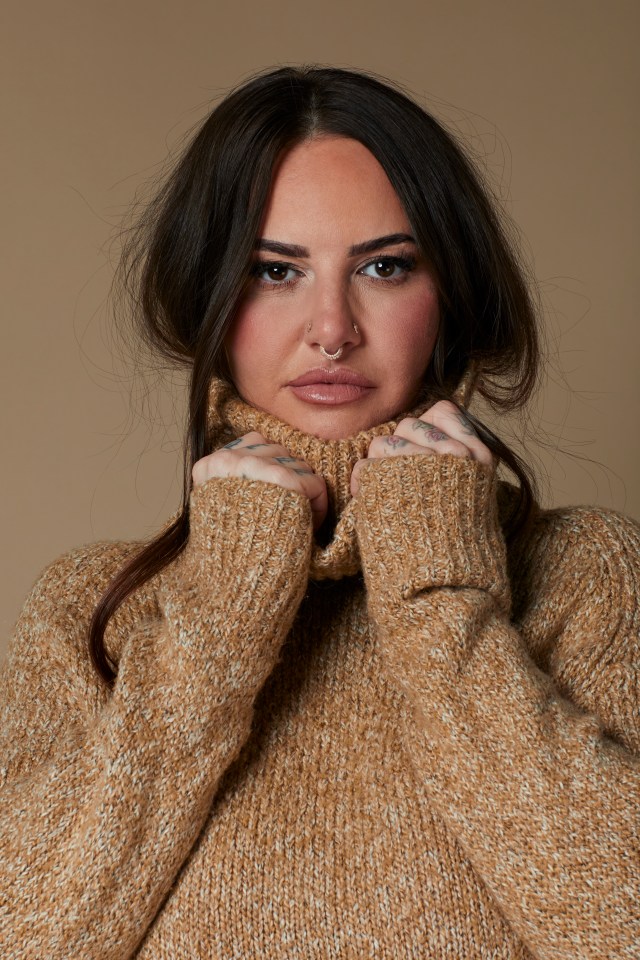 Portrait of Jemma Lucy wearing a brown turtleneck sweater.