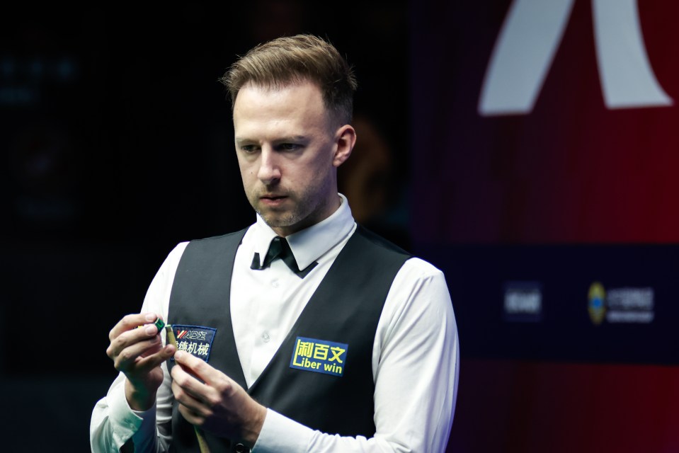 Judd Trump chalking his cue.