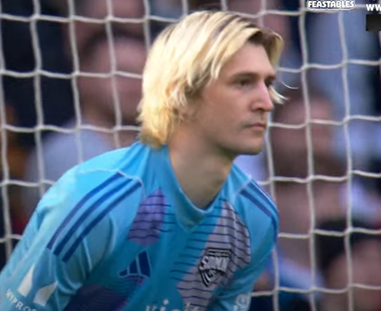 Goalkeeper standing by soccer goal.