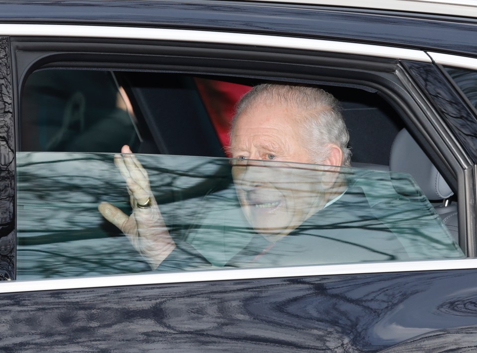 King Charles waving from a car.