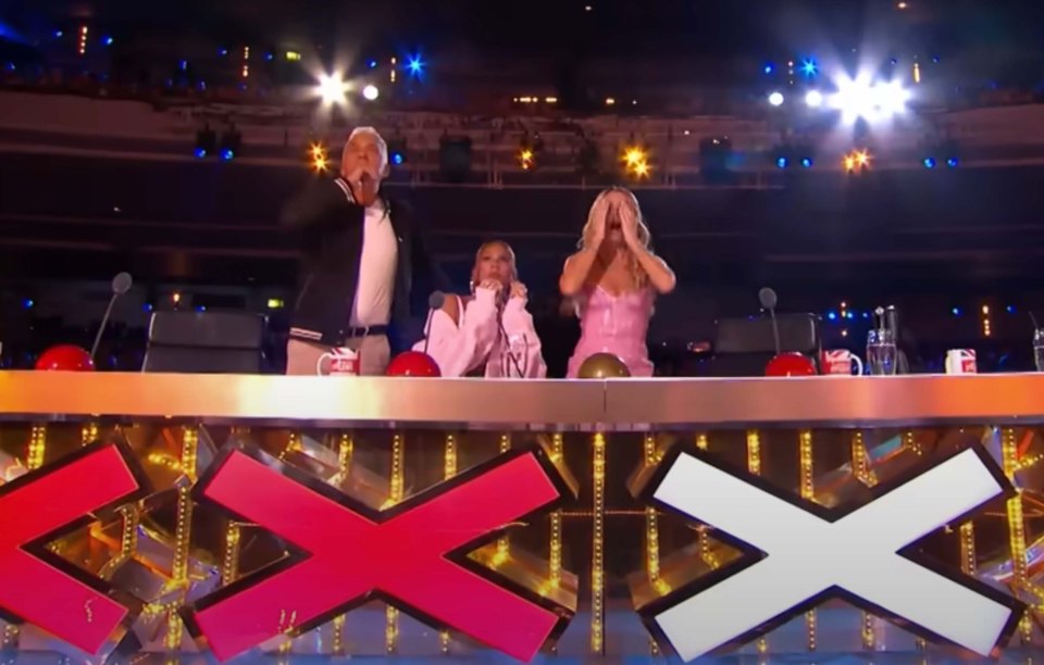 Three judges at a talent show judging panel react to a performance.