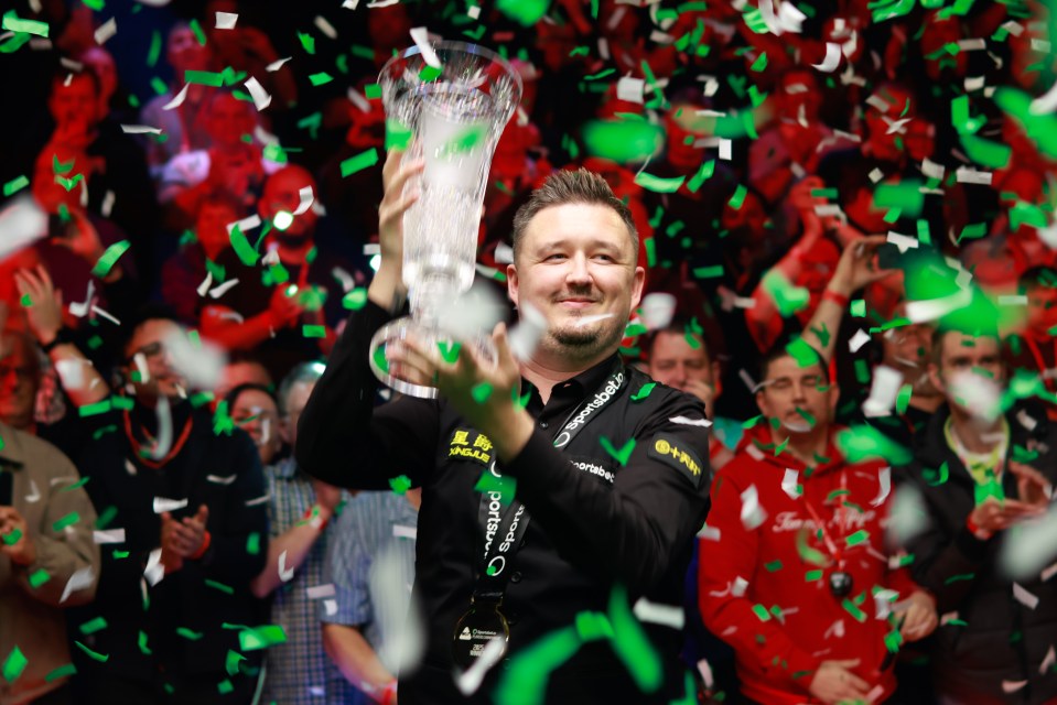 Kyren Wilson of England celebrates winning a trophy.