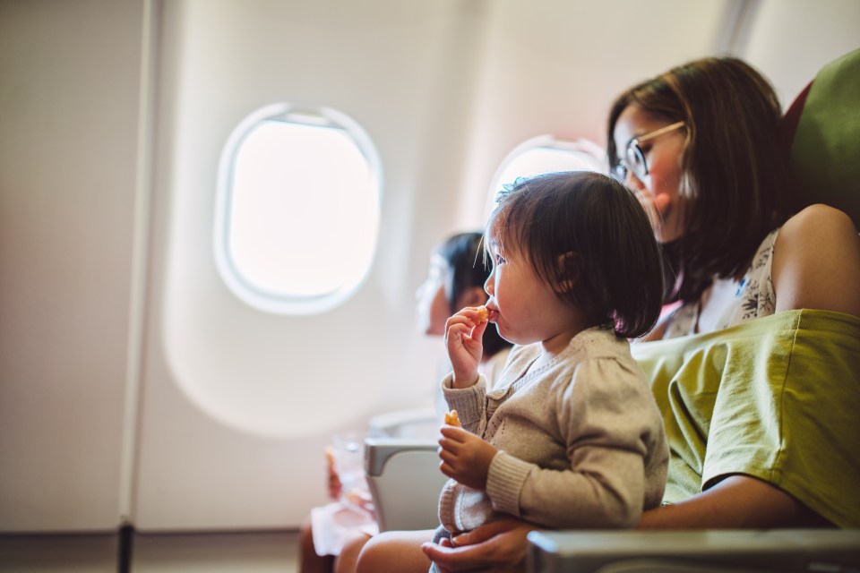 Toddler eating a snack on an airplane.