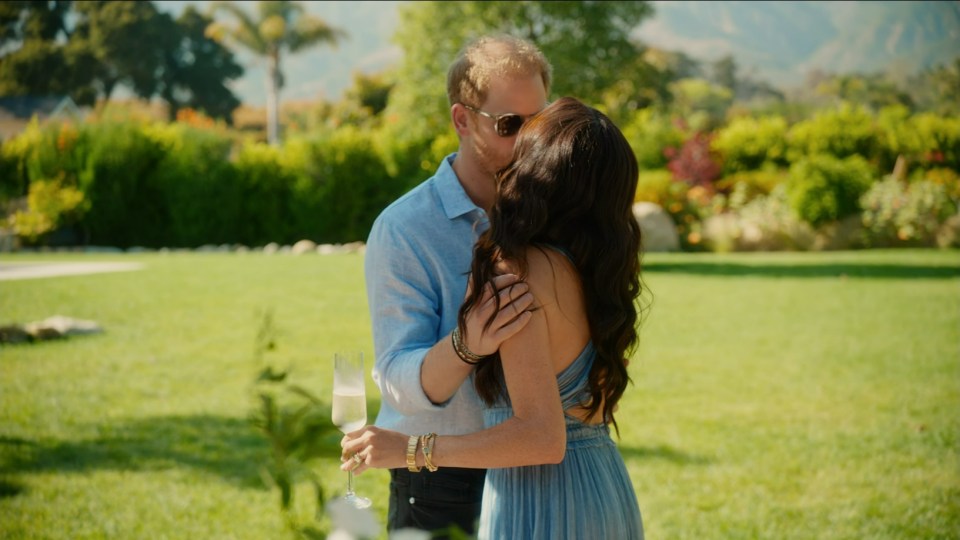Prince Harry and Meghan Markle kissing in a garden.