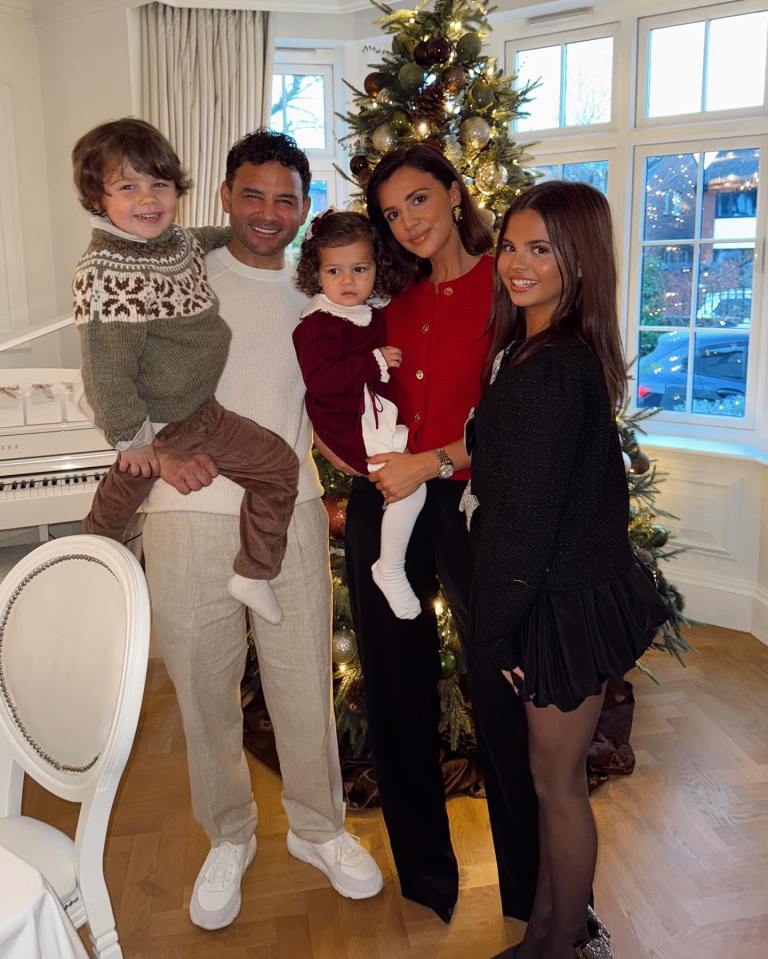 Family posing by a Christmas tree.