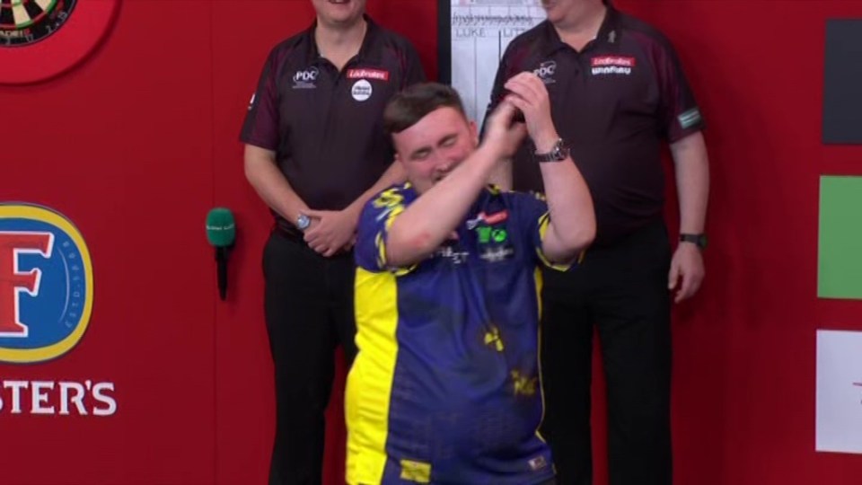 Darts player Luke Littler celebrates.
