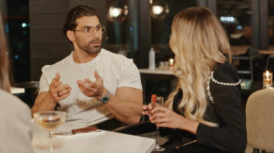 A man and woman having a conversation at a restaurant.