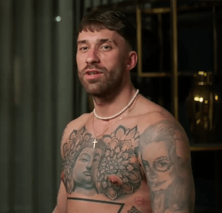 Man with chest and arm tattoos.