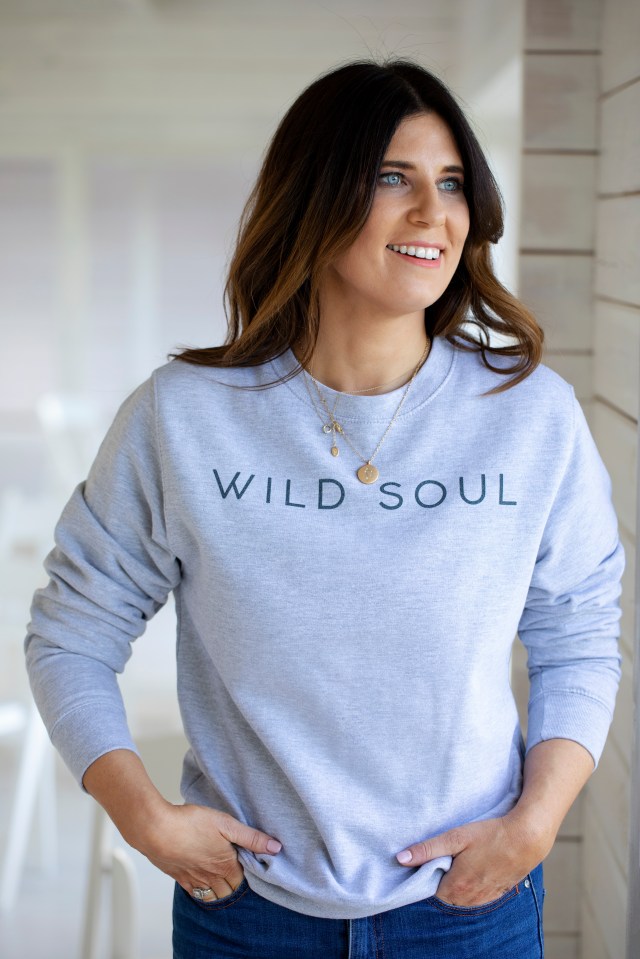 Woman wearing a "Wild Soul" sweatshirt.