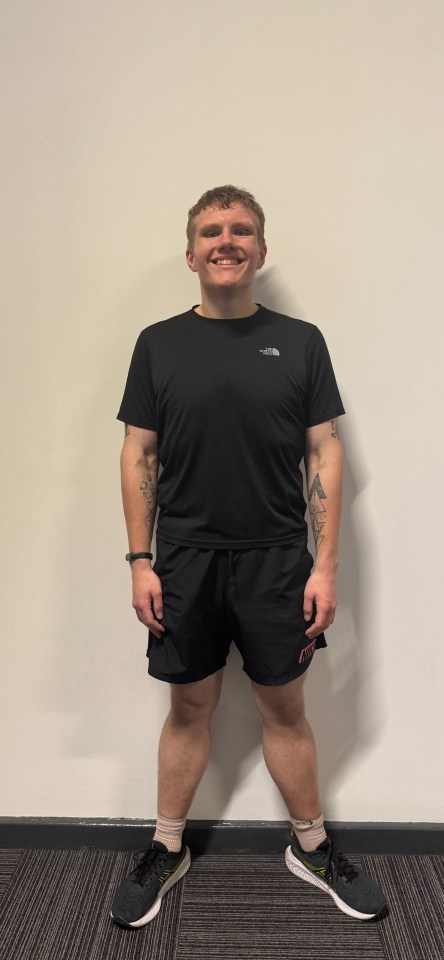 Man smiling, wearing black athletic wear.