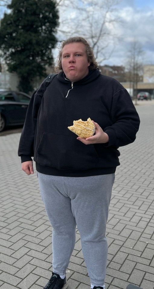 Man holding a partially eaten pastry.