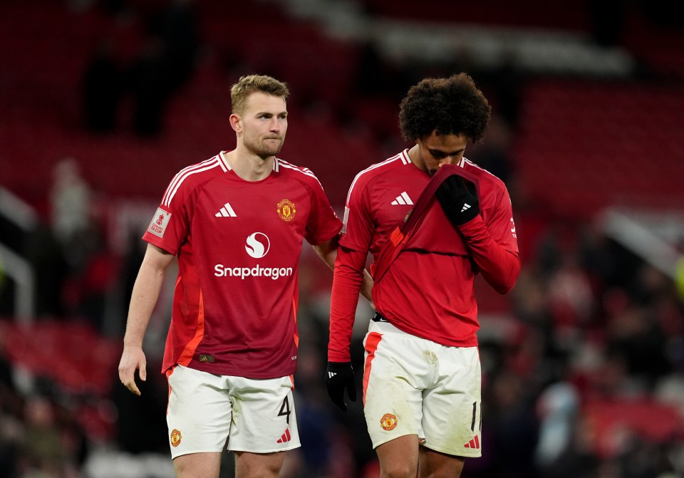 Two Manchester United soccer players looking dejected after a game.