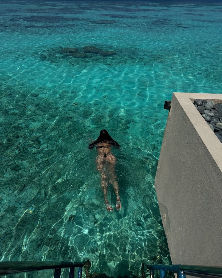 Person swimming in clear turquoise water.