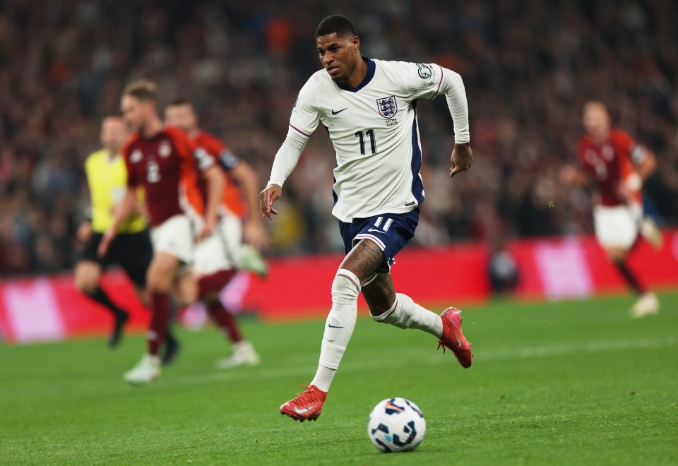 Marcus Rashford of England running with the ball during a soccer match.