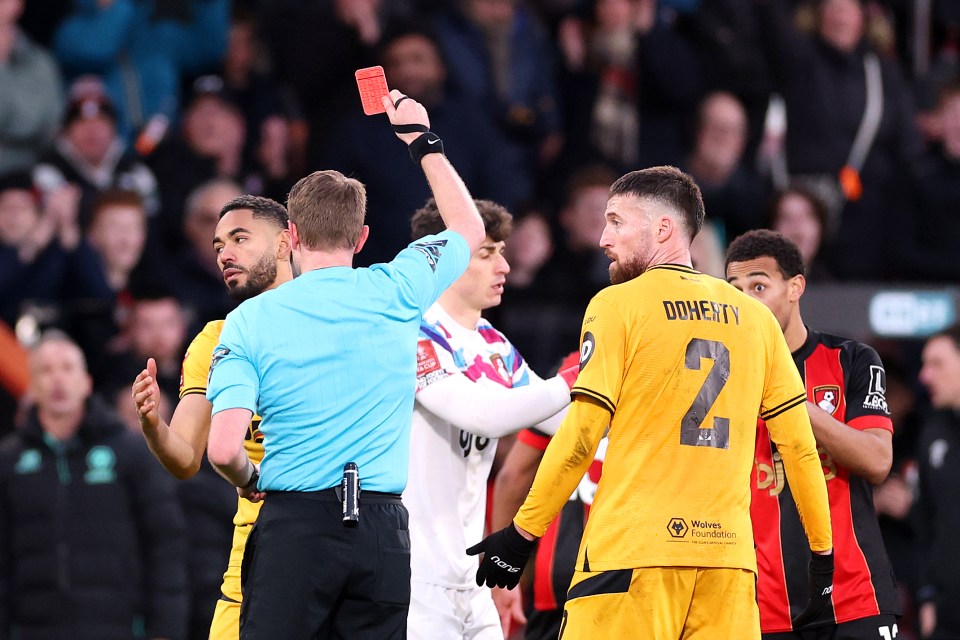 A referee shows a red card to a Wolverhampton Wanderers player.