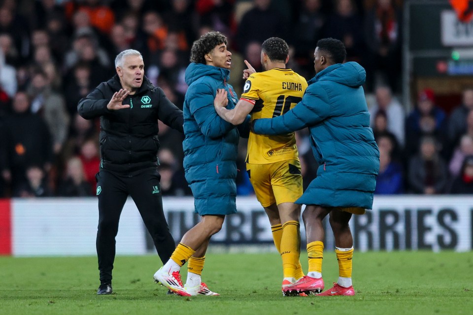 Matheus Cunha of Wolverhampton Wanderers is restrained by teammates after being sent off during a soccer match.