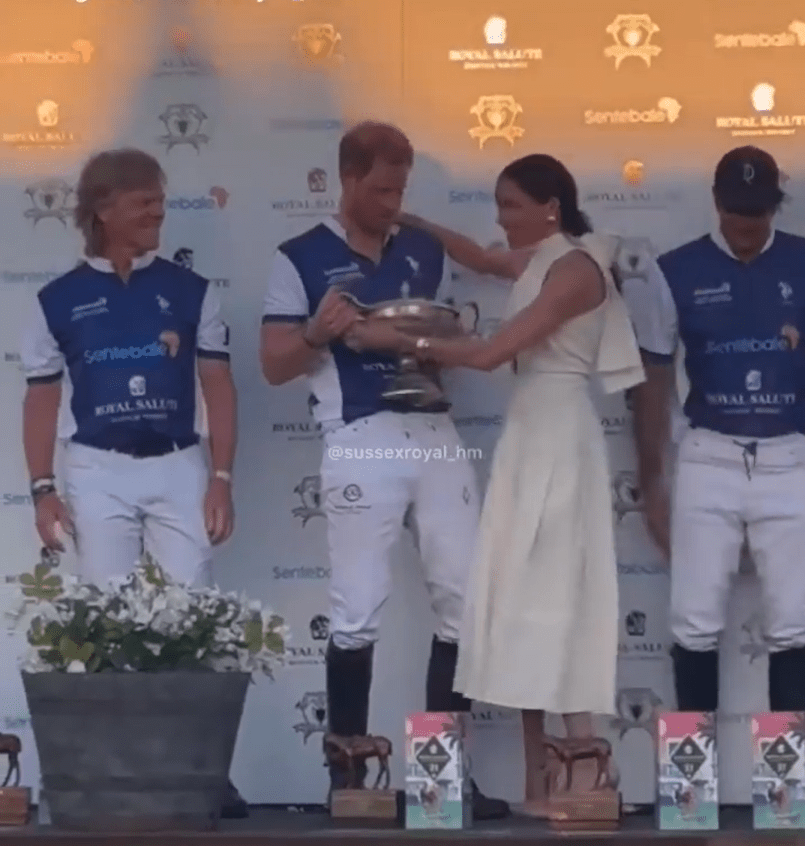 Meghan Markle and Prince Harry accepting a trophy at a polo match.