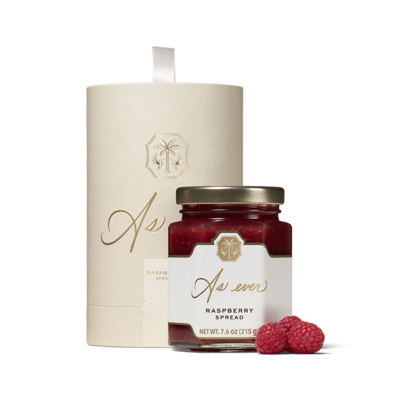 Raspberry spread in a jar with a gift box.