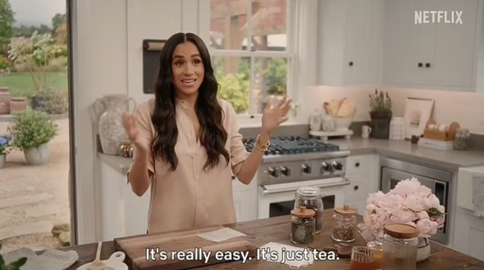 Meghan Markle making tea in a kitchen.