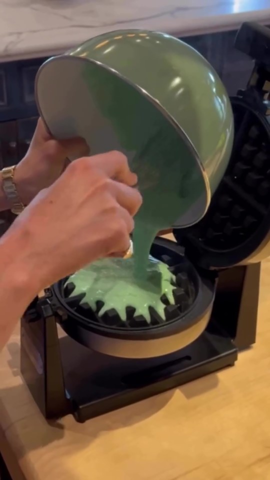 Screengrab of batter being poured into a waffle iron.