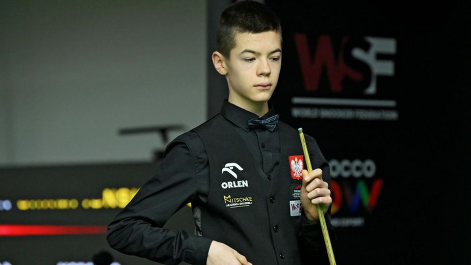 A young snooker player holding his cue.