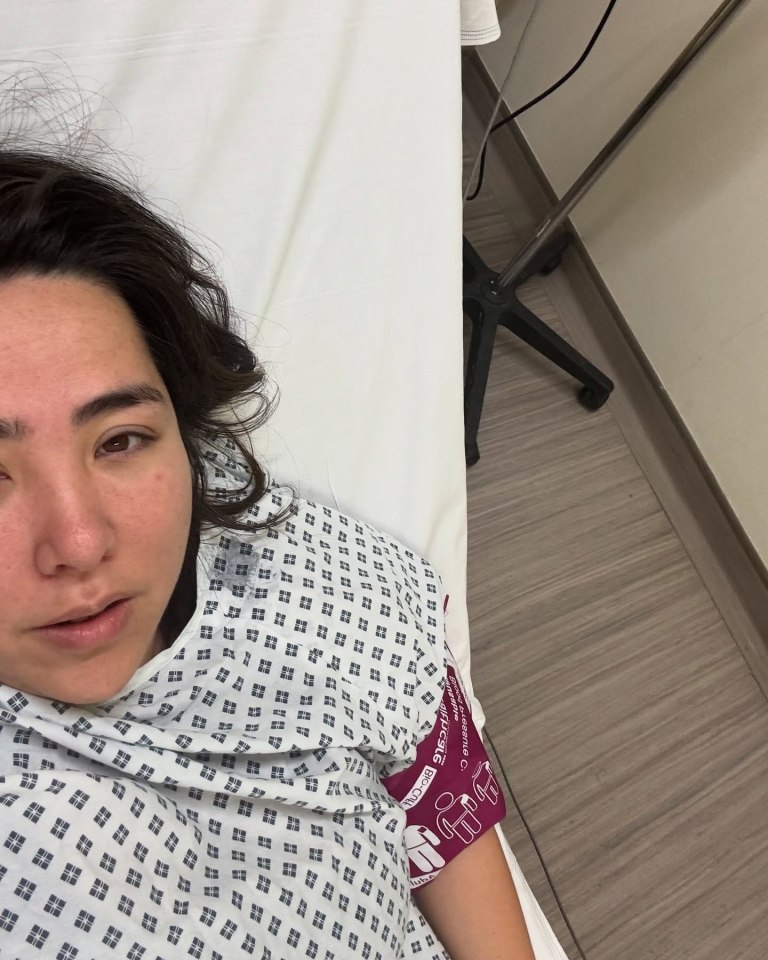 Woman in hospital gown lying on a hospital bed.