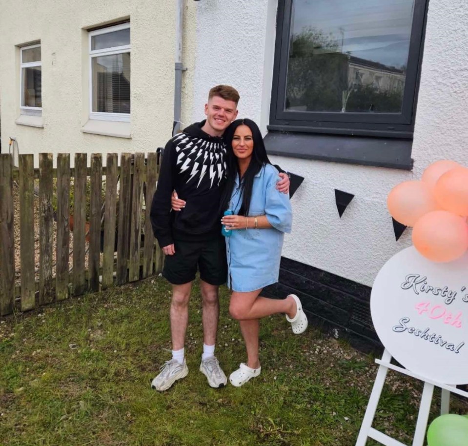 Photo of a mother and son standing outside a house.