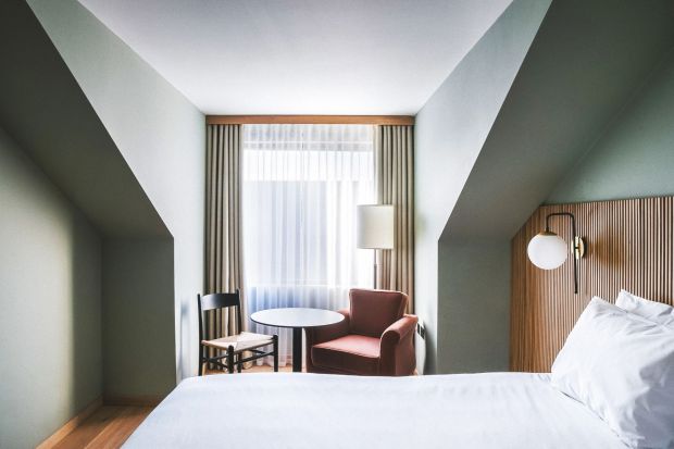 An image collage containing 1 images, Image 1 shows Hotel room with a bed, armchair, and small table
