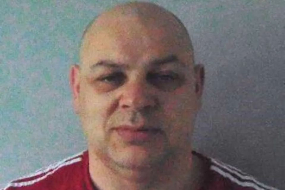 An image collage containing 1 images, Image 1 shows Mugshot of a bald man in a red shirt