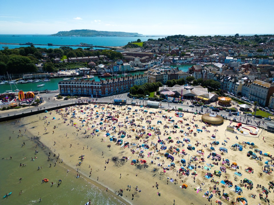 Aerial view of a crowded beach in Weymouth, England.