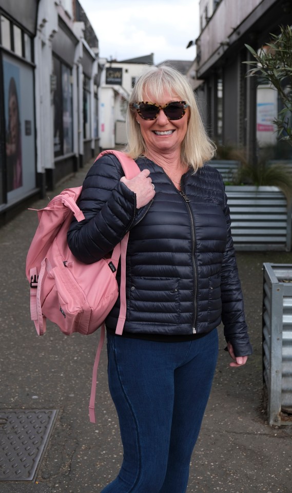 Woman wearing sunglasses and a pink backpack.