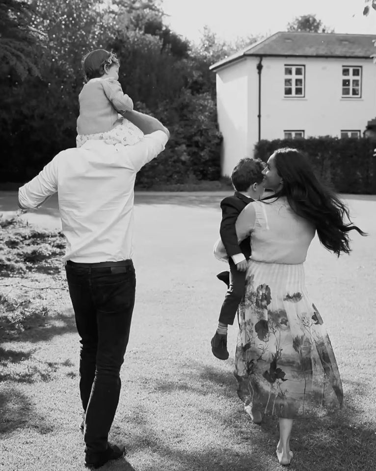 Black and white photo of Prince Harry and Meghan Markle carrying their children.