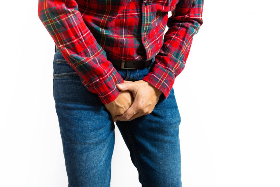 Man holding his groin in pain.