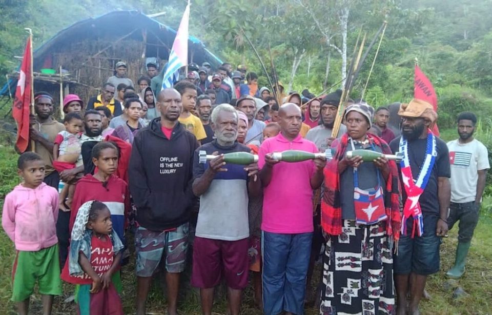 West Papuan refugees holding unexploded drone bombs.