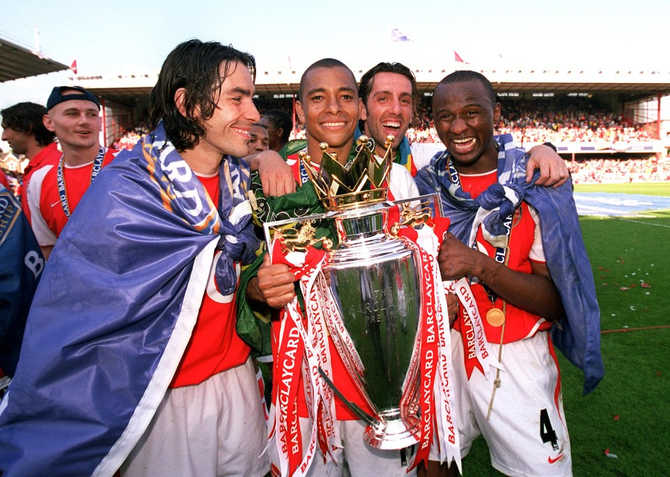 Arsenal players celebrating with the Premier League trophy.