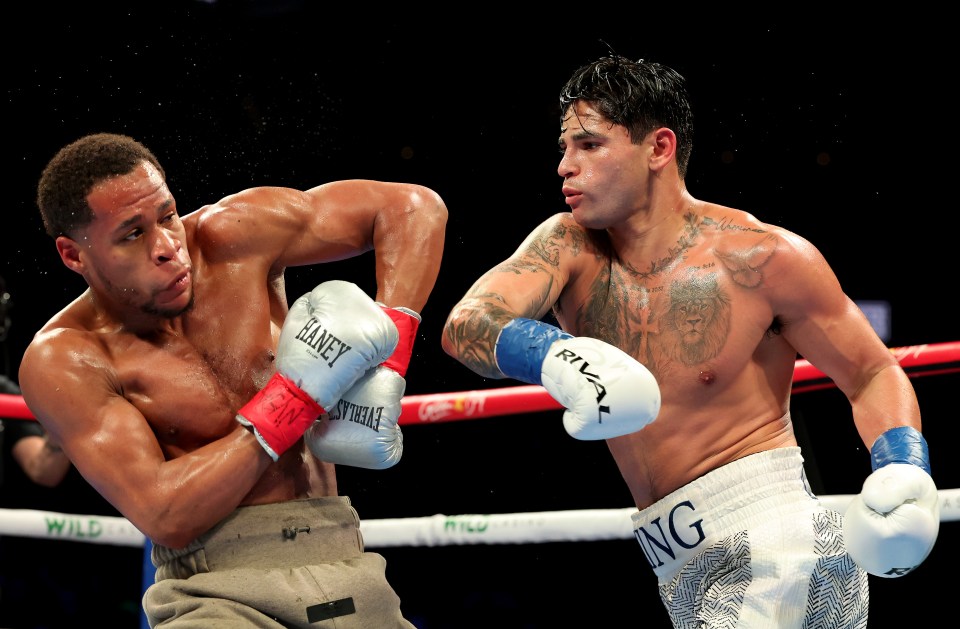 Ryan Garcia (white trunks) punches Devin Haney during a boxing match.
