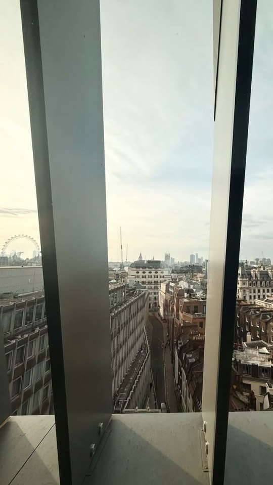High-angle view of London cityscape seen through a modern building's frame.