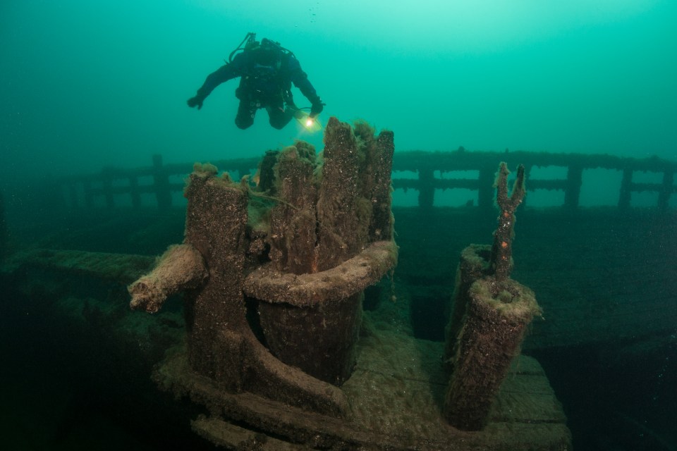Scuba diver exploring a wooden shipwreck.