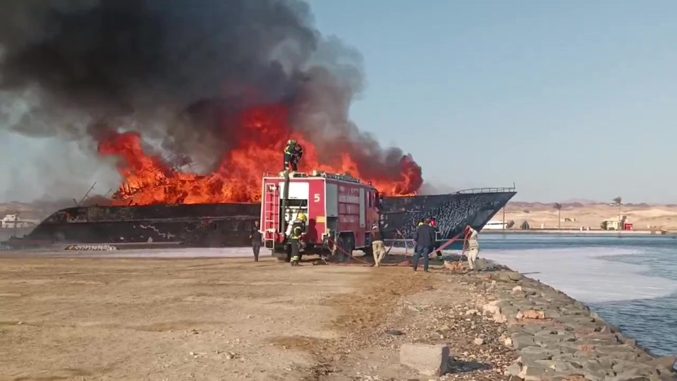 Firefighters battling a large fire on a yacht.