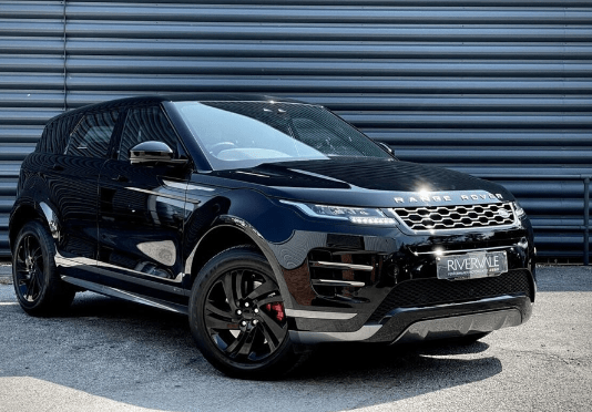 Black Range Rover parked in front of a corrugated metal wall.