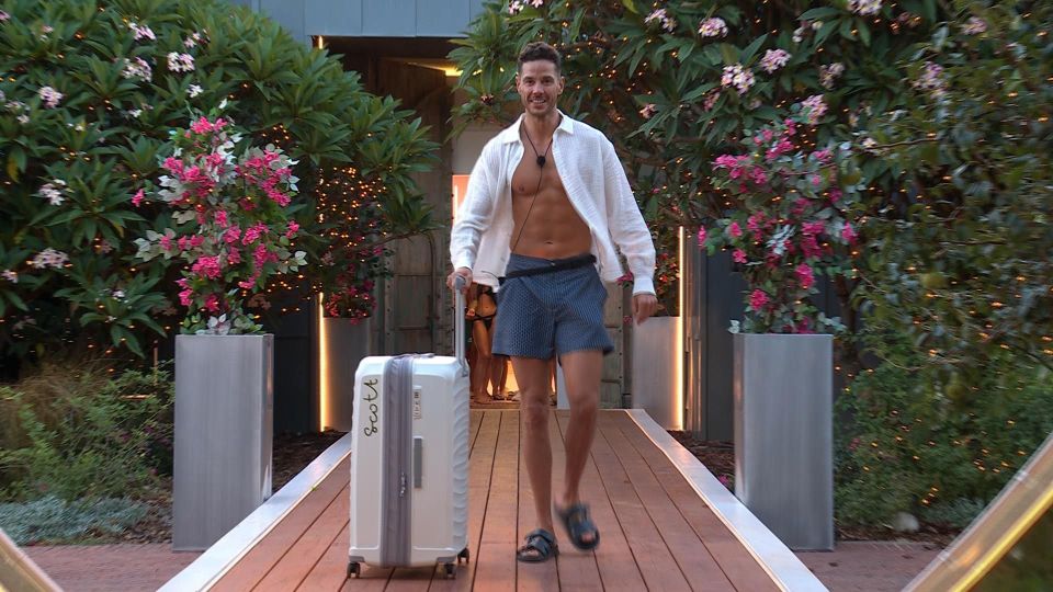 Scott Thomas arriving at Love Island with a suitcase.