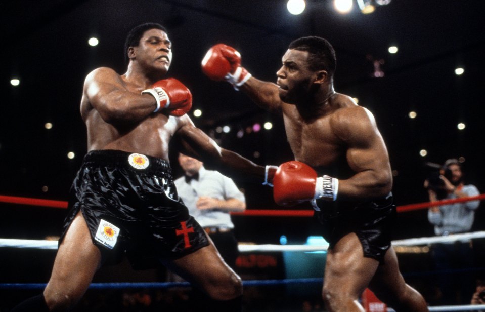 Mike Tyson throwing a punch at Trevor Berbick during a boxing match.