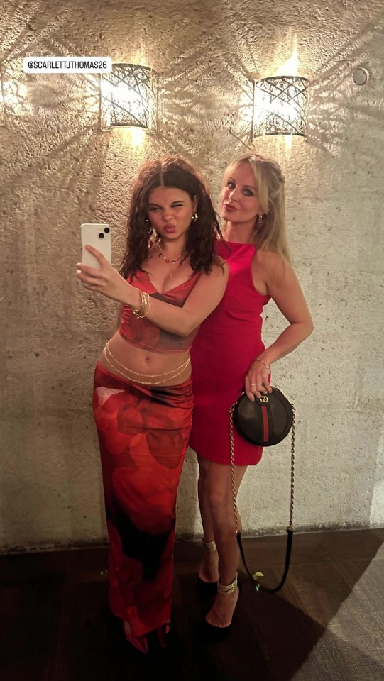 Two women in red outfits taking a selfie.