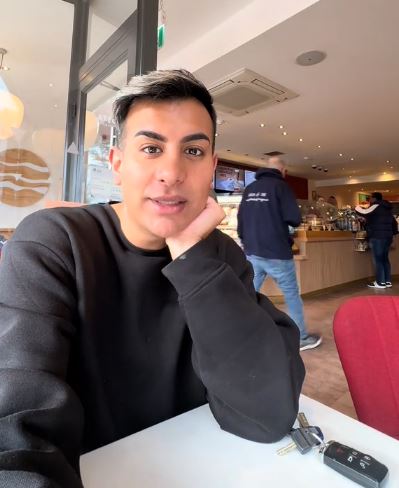 Man sitting in a cafe, looking concerned.