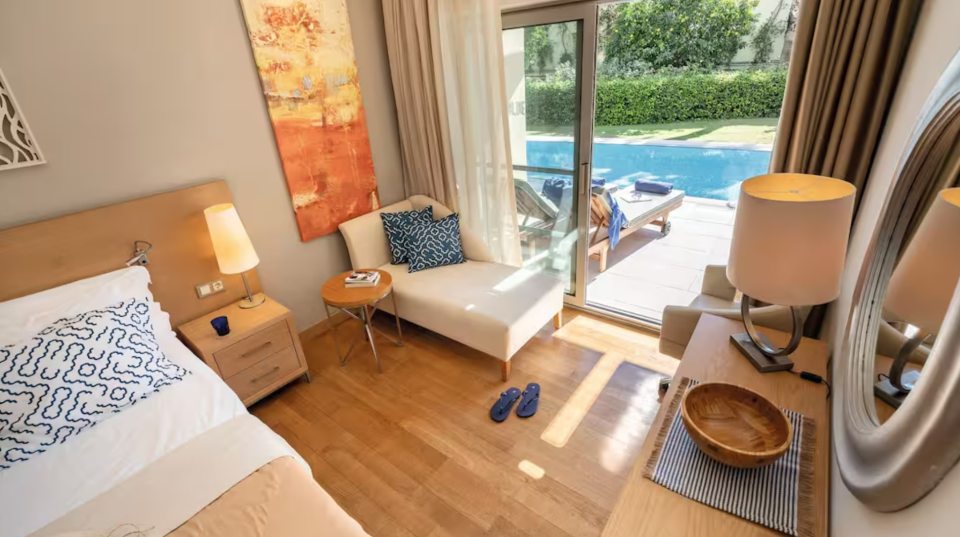 Hotel room with a view of a private pool.