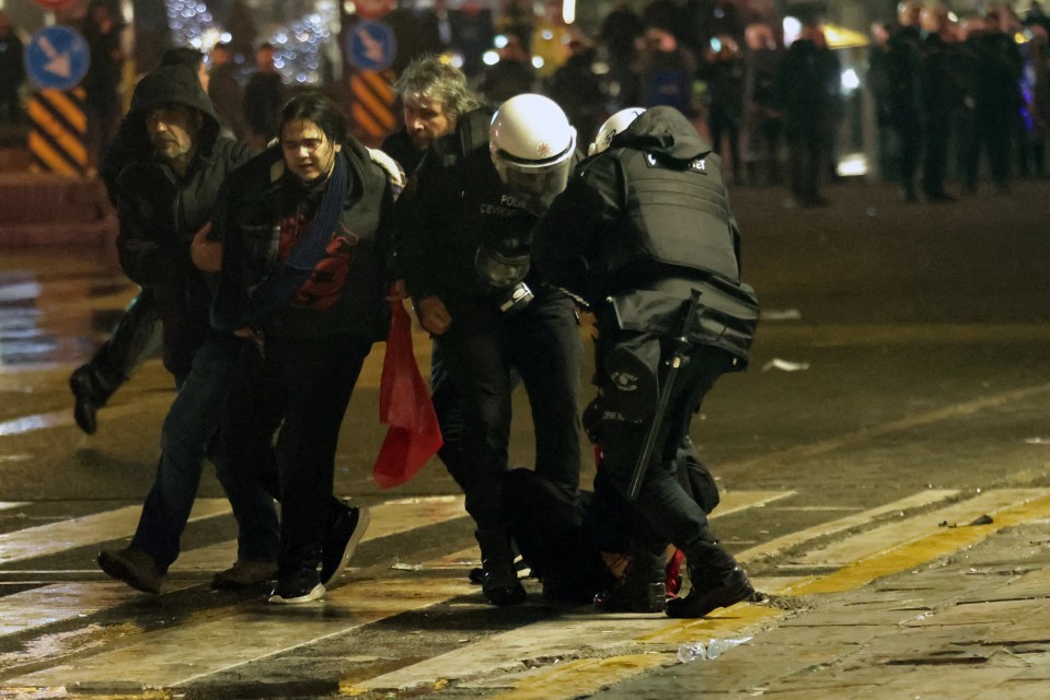 Turkish riot police detaining protesters.