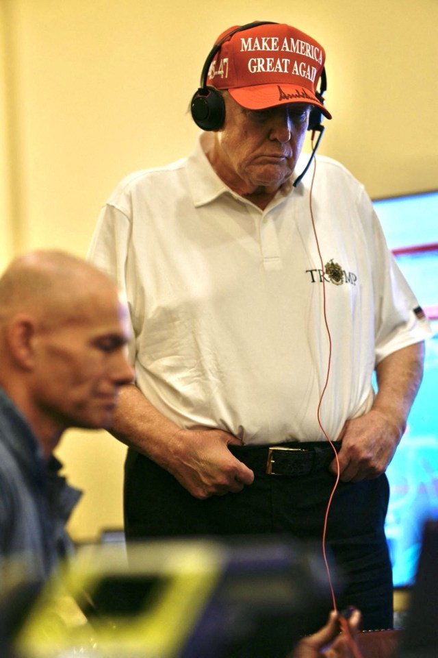 Donald Trump wearing a "Make America Great Again" hat and headset.
