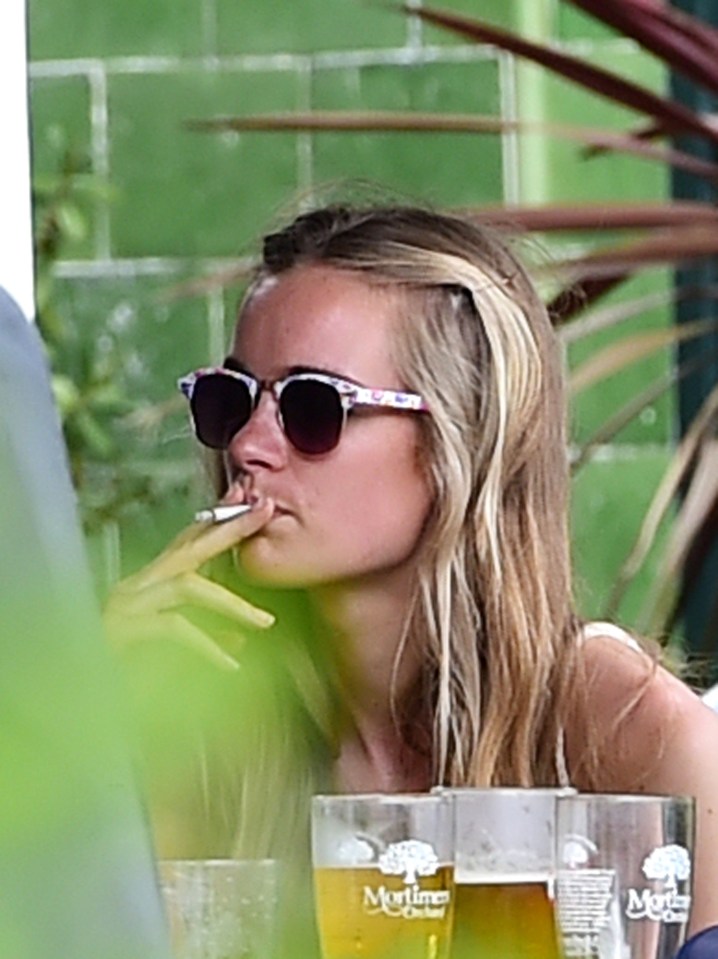 Cressida Bonas smoking a cigarette at a bar.